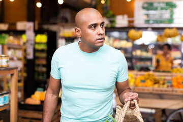 Portrait of man with bag at grocery store closeup