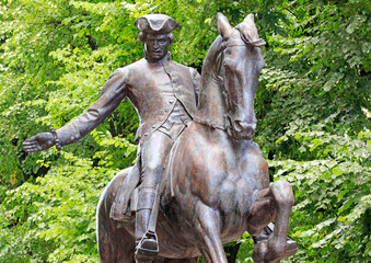 Statue of Paul Revere on Boston's Freedom Trail historic tourist walk with green background,...