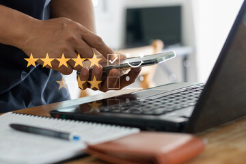 Customer service and Satisfaction concept, Businessperson are touching the virtual screen on the happy Smiley face icon to give satisfaction in service. By giving the most satisfaction rating 5 stars.