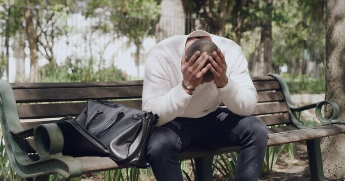 Accident, insurance and clumsy man dropping a laptop while working in outdoors in a park. Surprised, shocked and upset man breaking his computer while sitting on a bench outside
