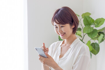 スマホを操作する笑顔の女性