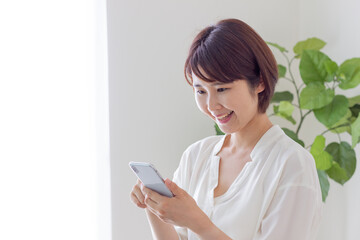 スマホを操作する笑顔の女性