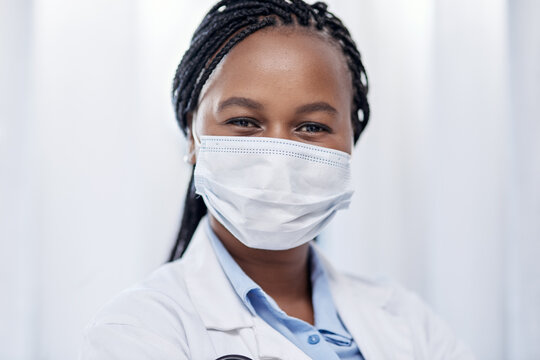 Doctor Wearing Hygiene Face Mask For Covid, Safety And Precaution In The Healthcare Industry. Portrait And Face Of Confident Black Medical Practitioner And Coronavirus Frontline Worker In A Hospital