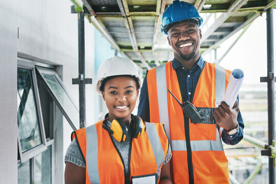 Happy And Proud African American Engineers At A Construction Site Planning A Building Together. Portrait Of Young Contractors Standing At An Apartment To Be Renovated For A Project Together