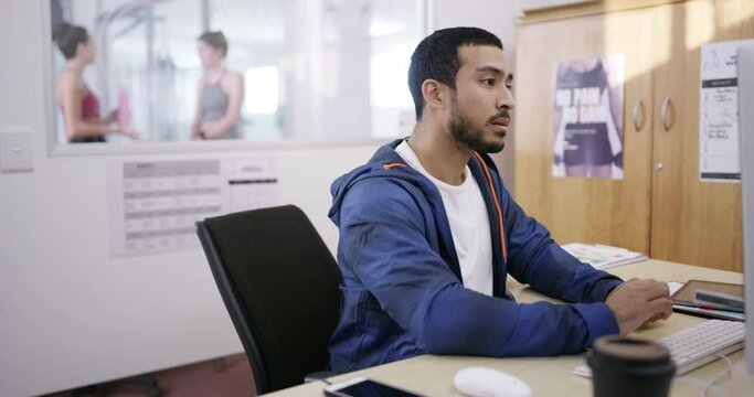 Fitness coach, personal trainer and gym owner thinking, typing and scheduling appointments on a computer in his office. Young man working on a workout plan, exercise routine or health schedule