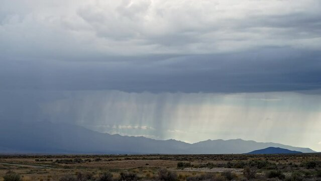 Ribbons of rain falling during storm in the Utah desert in Rush Valley during monsoon season.
