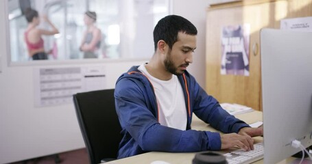 Gym manager or owner working in an office typing a business growth proposal or strategy on a computer. Fit and young fitness facility employees writing and planning a budget for the startup