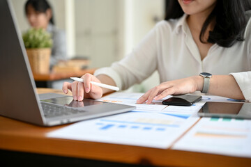 A businesswoman or financial analyst working at her office desk. cropped image