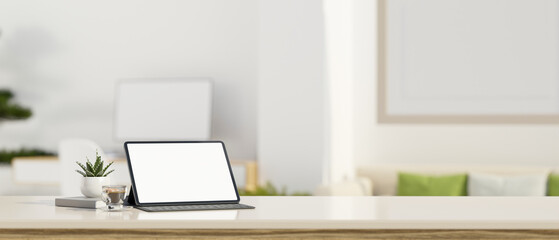 Workspace tabletop with tablet screen mockup and copy space over blurred white living room.