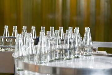 Bottles of product of fruit juice on the conveyor belt in the beverage factory. Bottling line for processing and bottling Basil seed with fruit into bottles. Food, health and Beverage industry