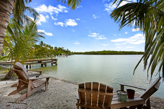 Bay Water View with Mangroves and Palm Trees Surrounding and Outdoor Furniture in the Foreground in Sanibel Island, Florida