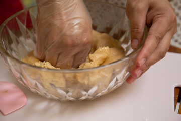 Female hands making dough for mooncake, homemade cantonese moon cake pastry on baking tray before baking for traditional festival. Travel, holiday, food concept