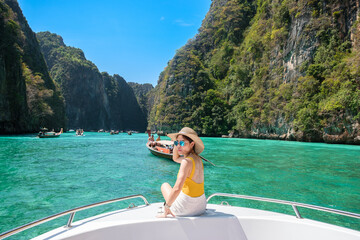 Woman tourist on boat trip, happy traveller relaxing at Pileh lagoon on Phi Phi island, Krabi, Thailand. Exotic landmark, destination Southeast Asia Travel, vacation and holiday concept