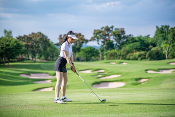 Professional woman golfer teeing golf in golf tournament competition at golf course for winner.	