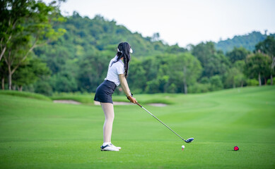Professional woman golfer teeing golf in golf tournament competition at golf course for winner.	
