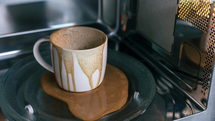 dirty coffee cup after operating with microwave oven, heating water in microwave can be dangerous,...