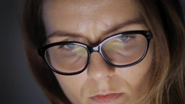 Young woman is browsing news or social information feed online with her laptop, smartphone or tablet device. Girl looks very calm and concentrated. She is a little bit tired, exhausted or depressed.