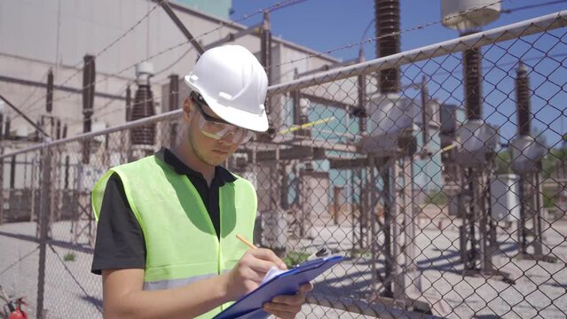 Electrical engineer at the switchyard.
The engineer walks through the switchyard taking notes.
