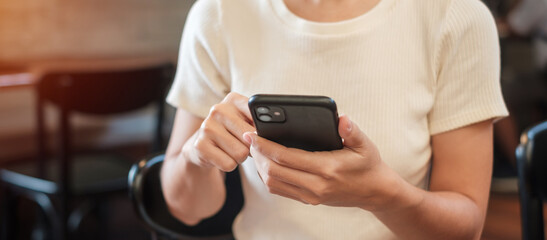 Casual Businesswoman holding and using smartphone for sms messages, young woman typing touchscreen mobile phone in cafe or modern office. lifestyle, technology, Social media and network concept