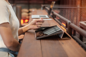 woman using tablet for sms messages, hand holding pencil typing touchscreen mobile phone in cafe or modern office. lifestyle, technology, Social media and network concept