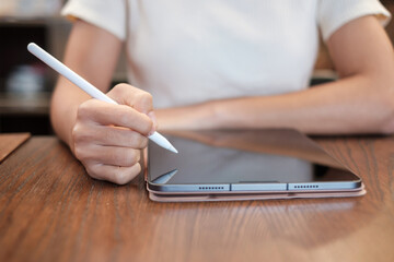 woman using tablet for sms messages, hand holding pencil typing touchscreen mobile phone in cafe or modern office. lifestyle, technology, Social media and network concept