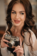 beautiful sexy brunette with a beautiful figure in sexy lingerie with a vintage camera