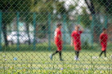 Metal mesh on a blurred background of a football field with players.