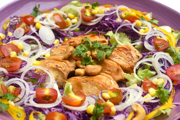  Pan fried chicken on a purple plate with greens and mulberry sauce