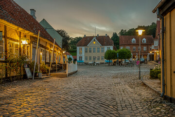 old cobblestone square with a half-timbered hotel in the evening twiligt hour
