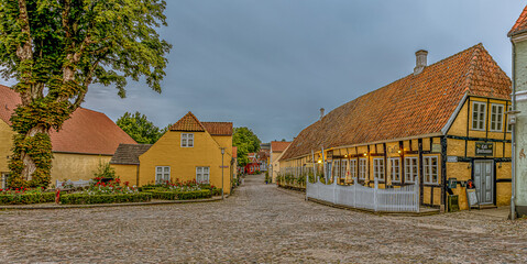 Panoramic wiev of a cobbelstone square and the old timber framed hotel Postgaarden in the danish...