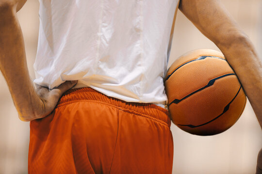 Basketball player holding game ball. Basketball training session. Closeup image of basketball