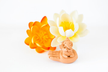 Lord Ganesha clay sculpture with lotus flower on white background, Hindu lord