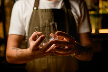 selective focus on caucasian male hands holding clean transparent empty glass for cocktail