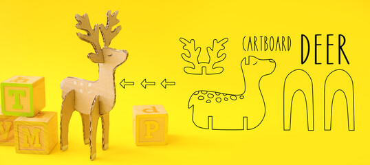 Handmade cardboard deer toy on yellow background