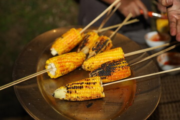 Delicious maize is being sold on the street of Varanasi in India during rainy season. Roasted and...