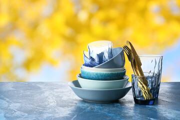 Set of clean dishes with cutlery on table outdoors