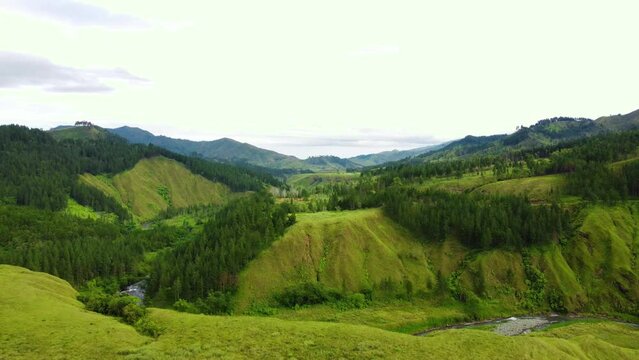 TILT DOWN DRONE SHOT OF A RIVER IN A MOUNTAINEOUS AREA
