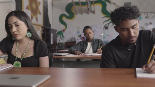 Native American students writing in class.