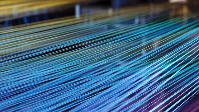 Yarn thread lines on the weaving loom machine in textile factory. Textile machine with red and yellow threads. Carpet factory, carpet production. Close up, 4K . 1