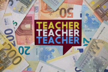 Teacher word with money. Paper currency background with different banknotes.