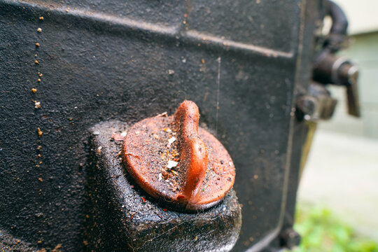 Close-up Red Plastic Oil Dipstick Cap In The Body Of A Dirty Motoblock Engine. Oil Filler Neck Of The Tractor. Oil Smudges And Adhering Dirt