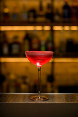 close-up on wine glass full of signature cocktail with tomato juice