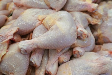 Chicken leg pieces stacked together in a shop for sale.