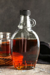 Bottle of maple syrup on grunge background, closeup