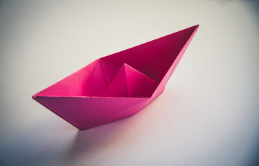 Pink paper boat origami isolated on a white background