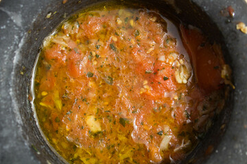 close-up of homemade tomato, garlic, oil and basil based preparation
in a mortar for the Italian recipe known as 