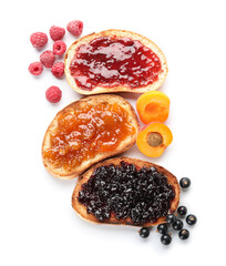 Toasts with different jams on white background