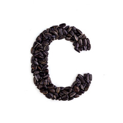 Capital letter C made from sunflower seeds. Alphabet made from sunflower seeds. White background. Sunflower seed font