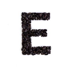 Capital letter E made from sunflower seeds. Alphabet made from sunflower seeds. White background. Sunflower seed font