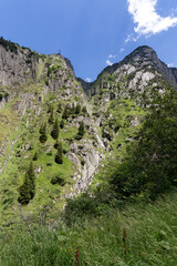 Narrow famous Schöllenen Gorge with Reuss River and beautiful scenic view of waterfall on a sunny summer day. Photo taken July 3rd, 2022, Andermatt, Switzerland.